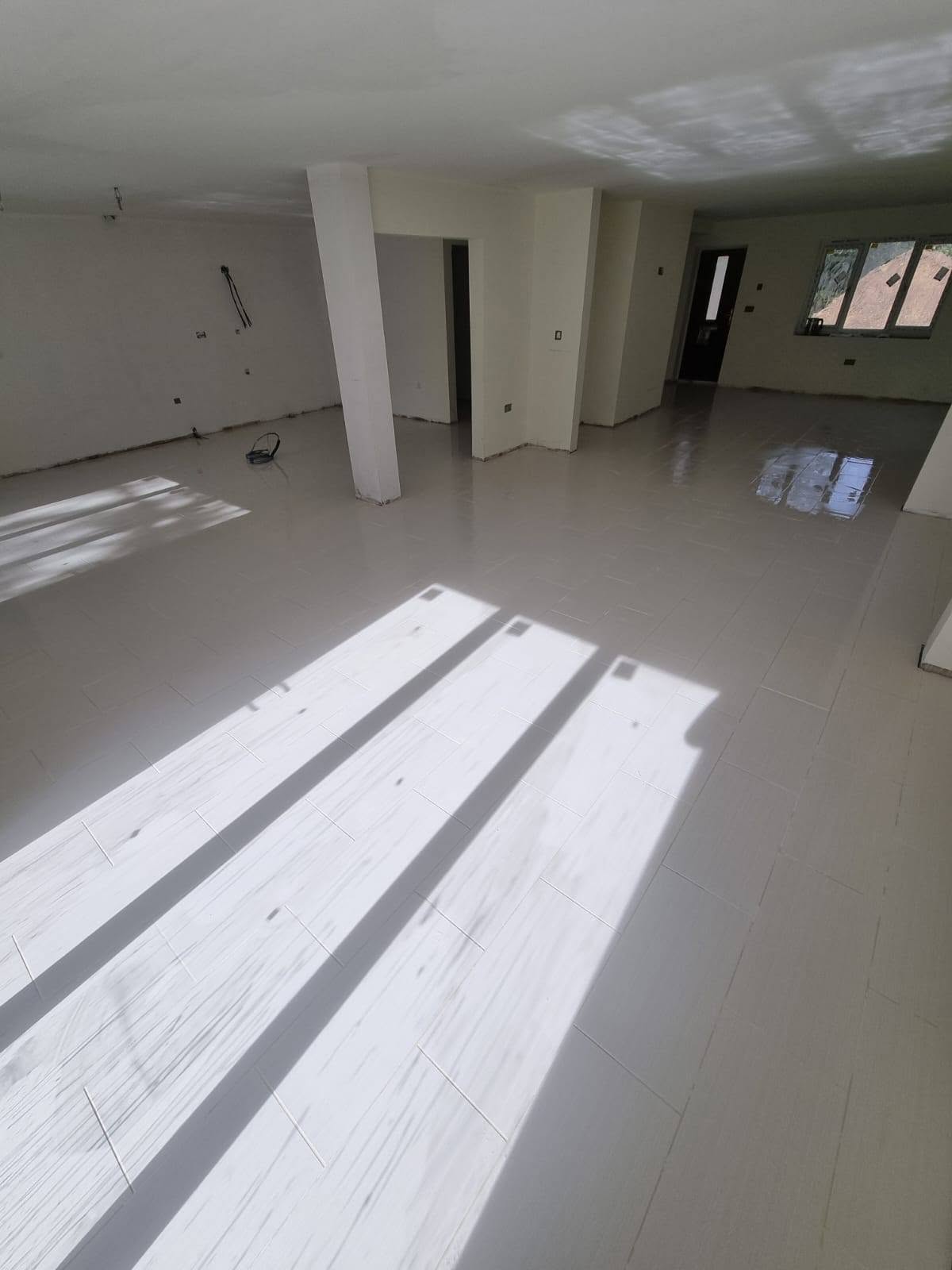 Freshly tiled floor across a large open-plan room