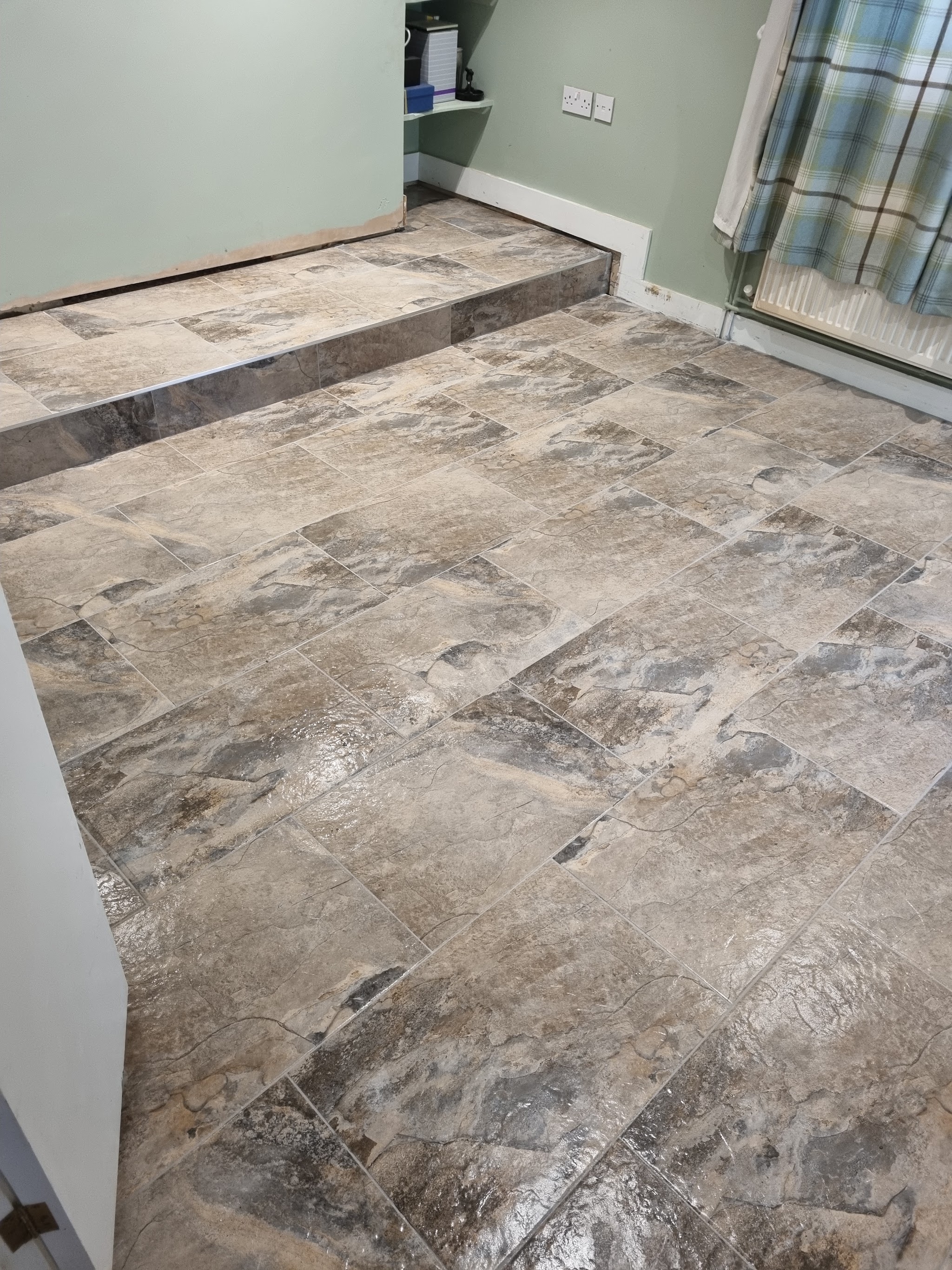 Stone-effect floor tiles laid across a stepped floor